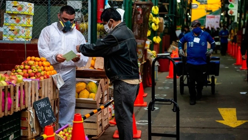 Người dân mua sắm tại một khu chợ ở thủ đô Lima của Peru. (Ảnh: Bloomberg)