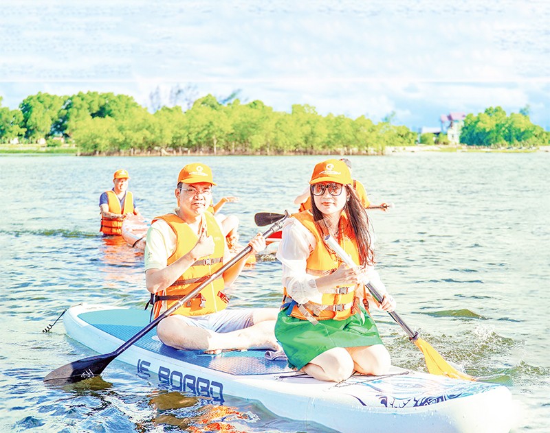 Du khách tham quan, khám phá rừng ngập mặn Rú Chá, xã Hương Phong, thành phố Huế bằng thuyền SUP.