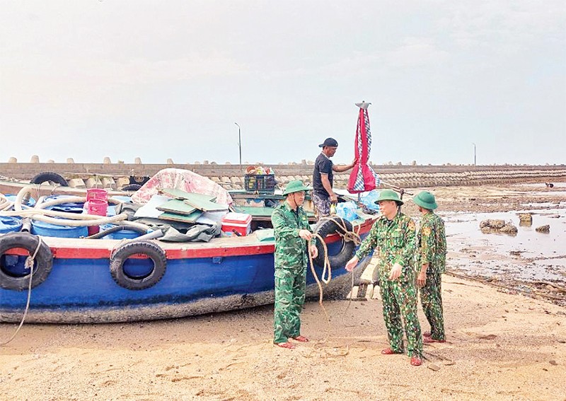 Cán bộ Đồn Biên phòng Bạch Long Vĩ (TP Hải Phòng) giúp ngư dân đưa tàu lên bờ tránh bão. (Ảnh VĂN TÁ)