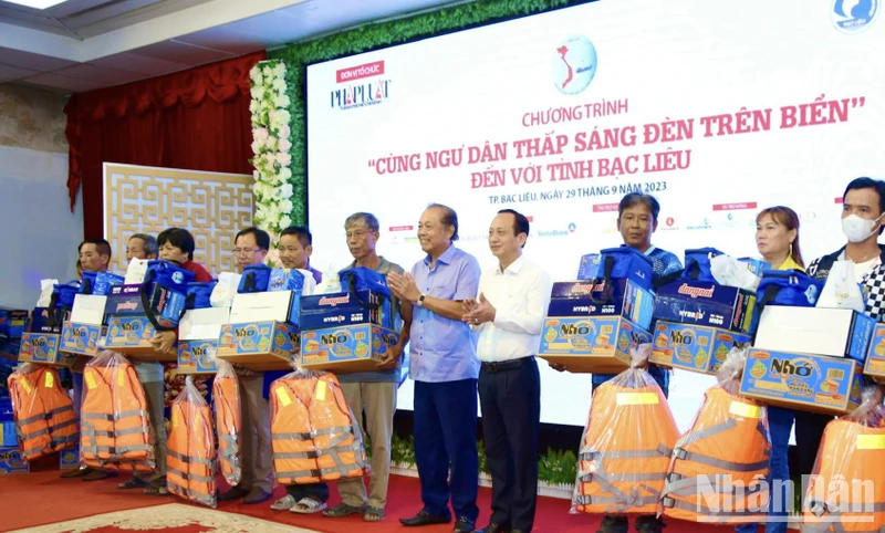 Đồng chí Trương Hòa Bình, Chủ tịch danh dự chương trình "Cùng ngư dân thắp sáng đèn trên biển" và Chủ tịch Ủy ban nhân dân tỉnh Bạc Liêu Phạm Văn Thiều trao tặng quà cho ngư dân Bạc Liêu.