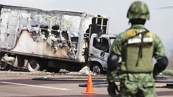 Cảnh sát Mexico phong tỏa hiện trường một vụ đốt phá xe do băng Sinaloa thực hiện. Ảnh: AP