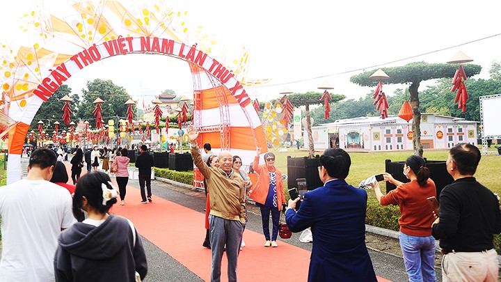 Người dân chụp ảnh lưu niệm bên cổng chào.
