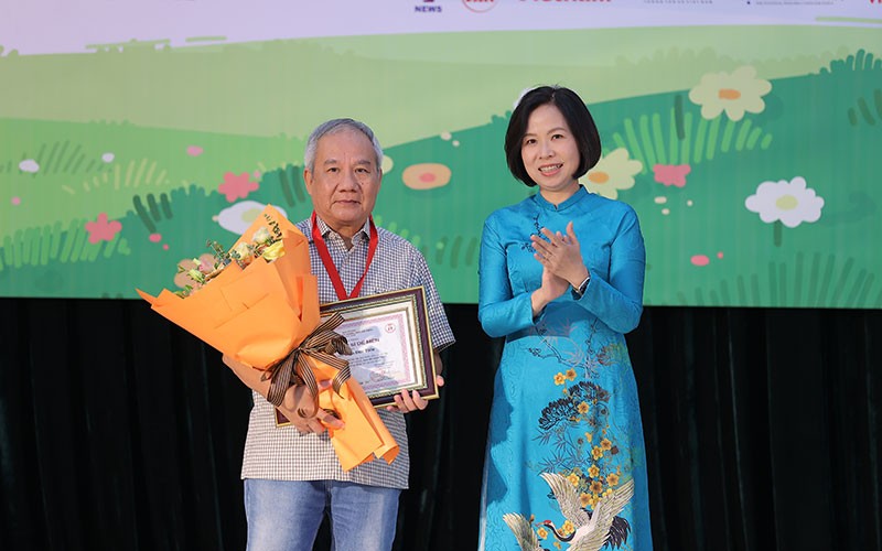 Tổng Giám đốc Thông tấn xã Việt Nam Vũ Việt Trang trao giải Hiệp sĩ Dế Mèn cho nhà văn Trần Đức Tiến. (Ảnh: Ban tổ chức)