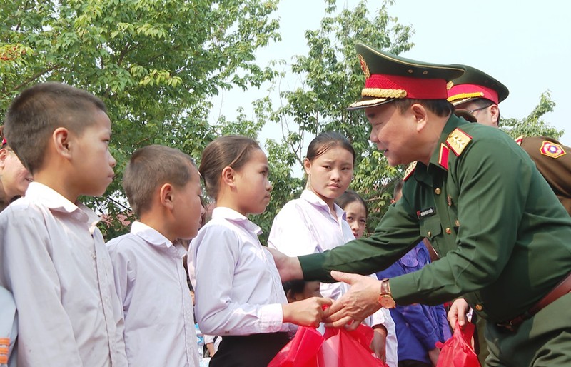 Thượng tướng Hoàng Xuân Chiến, Thứ trưởng Quốc phòng tặng quà các cháu học sinh tại cụm bản Pha Thi. (Ảnh: TRỊNH DŨNG)