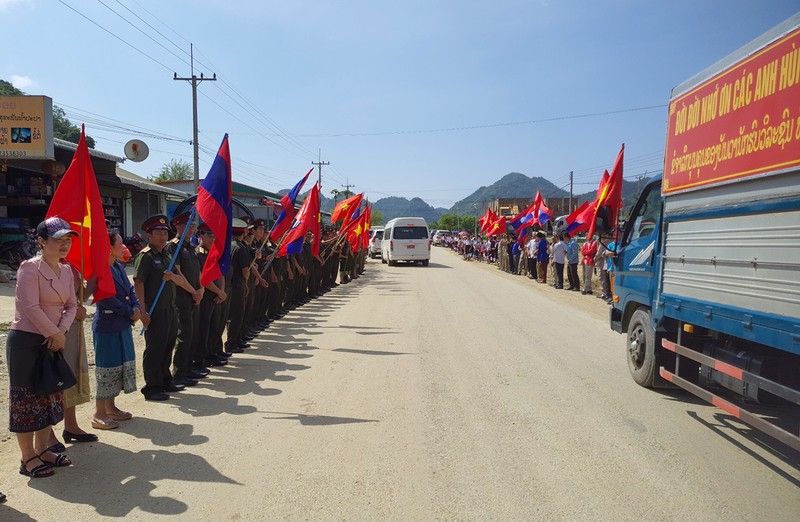 Đông đảo người dân tỉnh Xiengkhouang tập trung dọc hai bên đường vẫy cờ, hoa, viếng tiễn biệt các anh hùng liệt sĩ. (Ảnh: Trịnh Dũng)