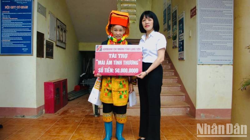 Đại diện lãnh đạo Ngân hàng nông nghiệp và Phát triển nông thôn chi nhánh (Agribank) Lạng Sơn, trao tặng, tài trợ tiền xây nhà cho gia đình Chị Hoàng Múi Phin. 