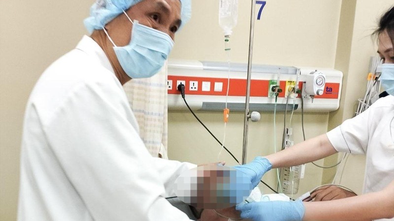 Bác sĩ Trần Minh Giang đang theo dõi nhịp tim của bệnh nhân Singapore. 