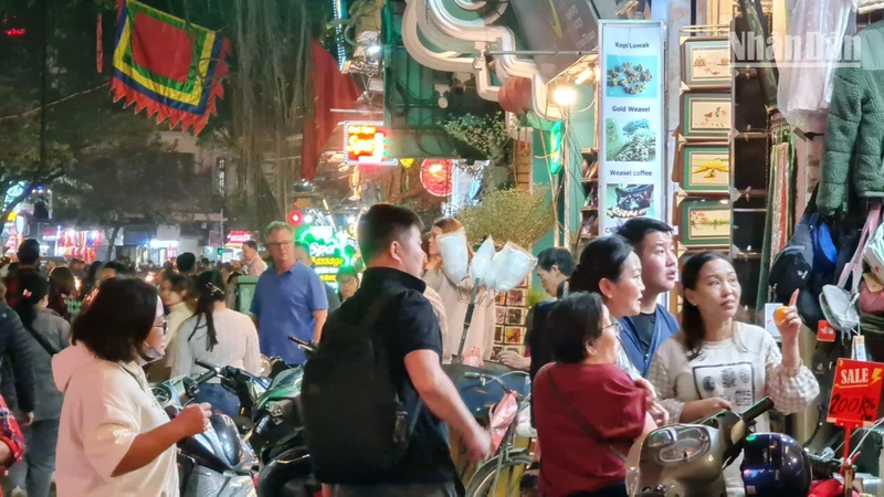 Du khách trên phố Hàng Bông, Hà Nội. (Ảnh: T.LINH)