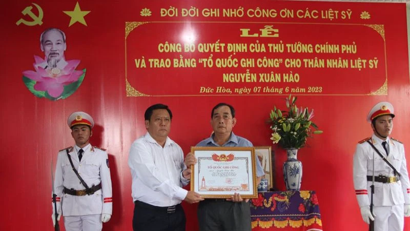 Lãnh đạo tỉnh Long An trao Quyết định của Thủ tướng Chính phủ và trao bằng "Tổ quốc ghi công" cho thân nhân Liệt sĩ Nguyễn Xuân Hào.