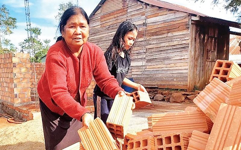 Người dân làng Tông Wil (thị trấn Nhơn Hòa, huyện Chư Pưh, tỉnh Gia Lai) dọn mặt bằng để đổ vật liệu xây nhà Đại đoàn kết mới. (Ảnh THIÊN DI)