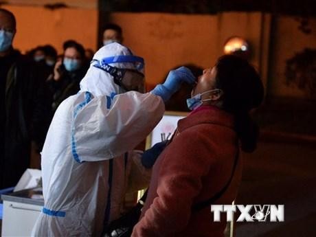 Nhân viên y tế lấy mẫu xét nghiệm Covid-19 cho người dân tại Thành Đô, thủ phủ tỉnh Tứ Xuyên, Trung Quốc. (Ảnh: AFP/TTXVN)