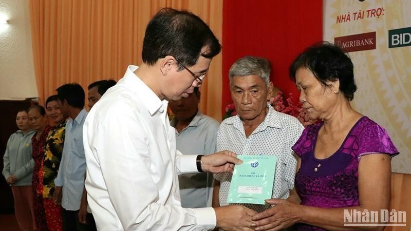 Ông Đào Việt Ánh, Phó Tổng Giám đốc Bảo hiểm xã hội Việt Nam tặng sổ Bảo hiểm xã hội cho người thân Phụng Hiệp.