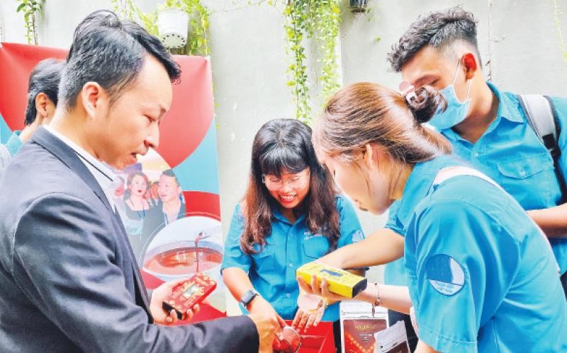 Giám đốc Nguyễn Hồng Huy giới thiệu về sản phẩm sô-cô-la do mình tạo ra với các bạn trẻ tại một ngày hội khởi nghiệp. 