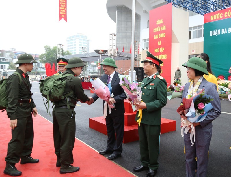 Bí thư Thành ủy Hà Nội Đinh Tiến Dũng tặng hoa cho các tân binh. 