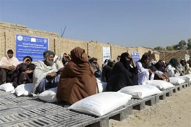 Người dân Afghanistan nhận lương thực viện trợ từ Chương trình Lương thực thế giới, tại Kandahar. (Ảnh: AFP/TTXVN)