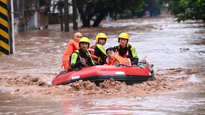 Lực lượng cứu hộ sơ tán người dân vùng lũ. (Ảnh: people.com.cn)