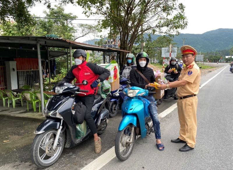 Người dân vui mừng đón nhận món quà nhỏ từ các chiến sĩ Cảnh sát giao thông Đà Nẵng.