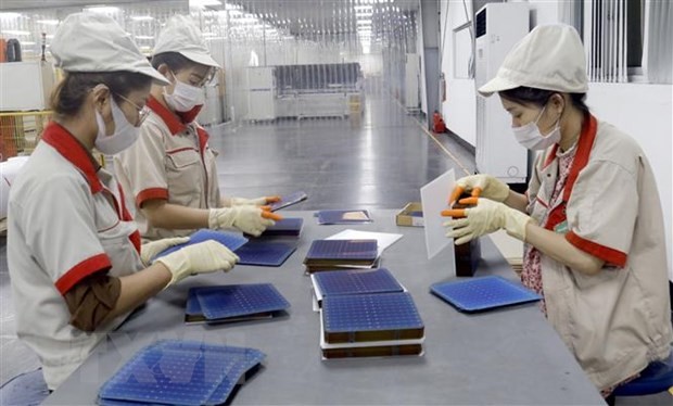 Công nhân Công ty cổ phần Vietnam Sunegry tại Khu công nghiệp Đình Trám, Bắc Giang trong dây chuyền sản xuất tấm pin năng lượng Mặt Trời. (Ảnh: Đồng Thúy/TTXVN)
