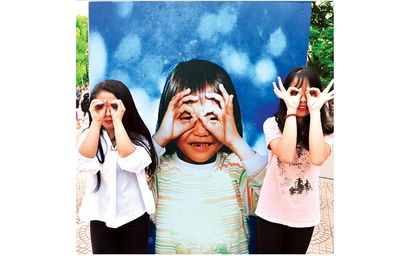 Hào hứng tạo dáng tại triển lãm "Thắp sáng nụ cười Việt Nam". Ảnh: THÀNH ĐẠT