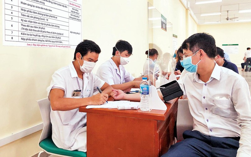 Khám sàng lọc cho người dân tiêm vắc-xin phòng Covid-19 tại Bệnh viện Bạch Mai. Ảnh | TRẦN HẢI