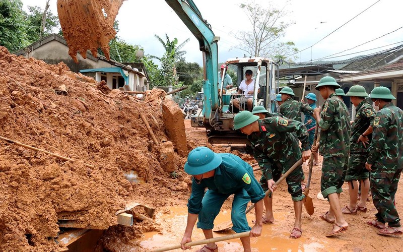 Lực lượng vũ trang tỉnh Thừa Thiên Huế dọn dẹp ngôi nhà của bà Nguyễn Thị Ðào, ở thôn Phước Tượng, xã Lộc Trì (huyện Phú Lộc) bị lũ quét tràn qua làm sập nhà. (Ảnh CÔNG HẬU)
