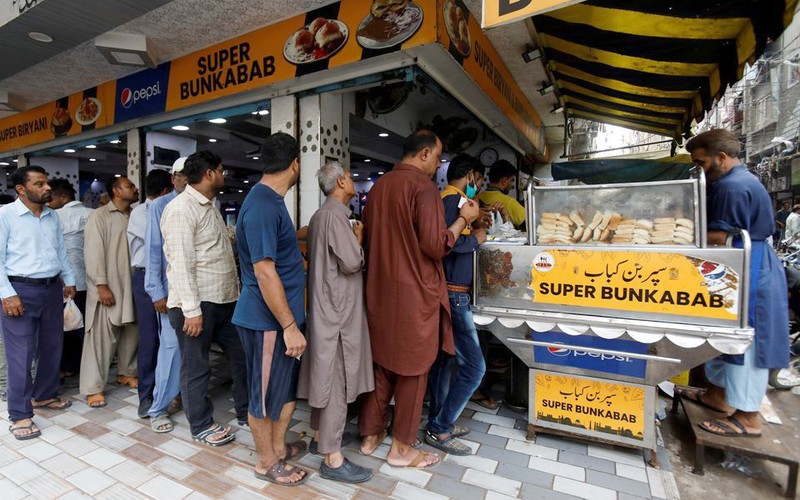 Người dân Pakistan xếp hàng chờ mua bánh mỳ giá rẻ tại thành phố Karachi. (Ảnh REUTERS)