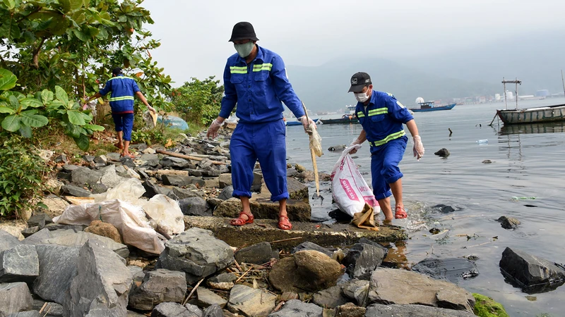 Công nhân vệ sinh môi trường thu gom rác thải nhựa tại khu vực vịnh Mân Quang, quận Sơn Trà, thành phố Đà Nẵng. 