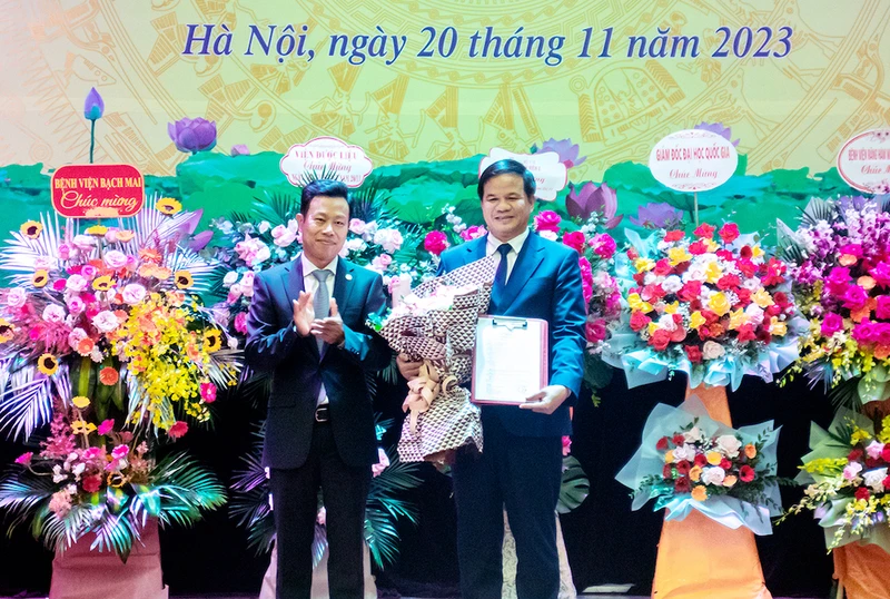 Giám đốc Đại học Quốc gia Hà Nội Lê Quân (bên trái) trao quyết định bổ nhiệm chức vụ Phó Hiệu trưởng Trường đại học Y Dược, Đại học Quốc gia Hà Nội cho Giám đốc Bệnh viện Bạch Mai Đào Xuân Cơ.