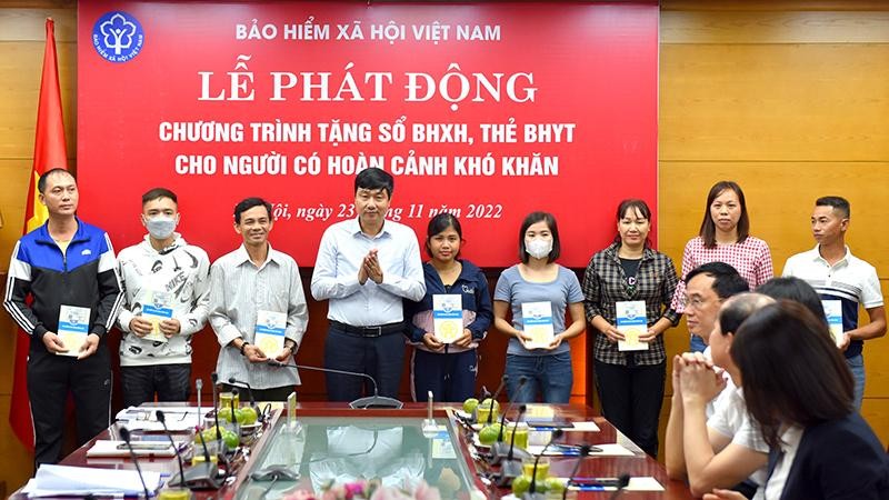 Trao tặng sổ bảo hiểm xã hội, thẻ bảo hiểm y tế cho người dân có hoàn cảnh khó khăn ở Hà Nội. (Ảnh: HSS)