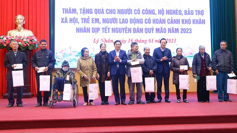 Bộ trưởng Đào Ngọc Dung, lãnh đạo tỉnh Hà Nam tặng quà gia đình chính sách tại huyện Lý Nhân. (Ảnh: Molisa)
