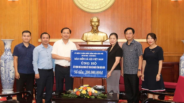 Phó Tổng Giám đốc Bảo hiểm xã hội Việt Nam Chu Mạnh Sinh trao 200 triệu đồng ủng hộ xây nhà đại đoàn kết cho hộ nghèo của tỉnh Điện Biên. (Ảnh: VSS)