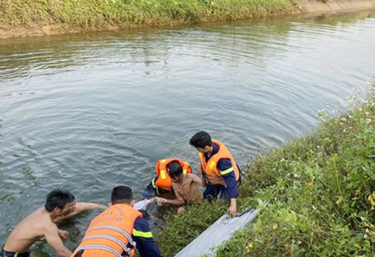 Lực lượng chức năng vớt thi thể anh P. dưới kênh thủy lợi Phú Ninh. 
