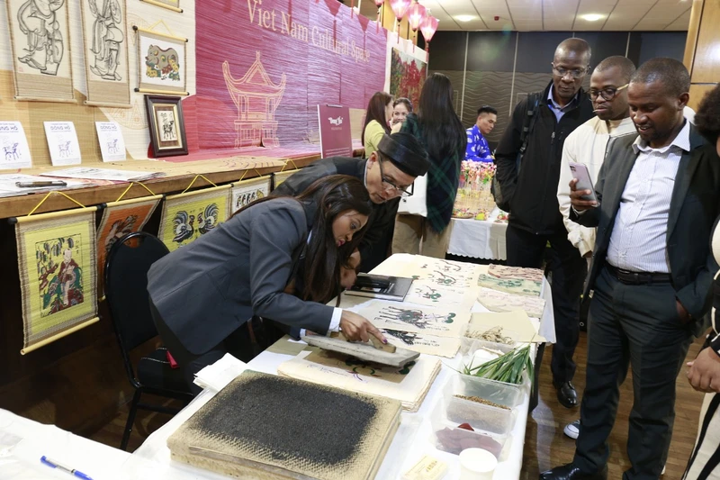 Người dân Nam Phi tham quan, tìm hiểu kỹ thuật in tranh Đông Hồ do nghệ nhân Nguyễn Đăng Tâm hướng dẫn (Ảnh: Vụ ngoại giao Văn hoá và UNESCO)