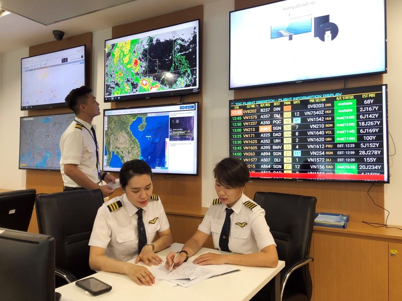 Cơ trưởng máy bay A350 Nguyễn Ly Hương (bên phải) trao đổi, chia sẻ kinh nghiệm bay với đồng nghiệp.