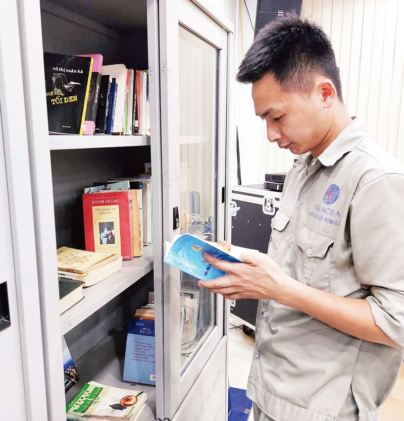 Công nhân đọc sách tại điểm sinh hoạt văn hóa công nhân ở Công ty cổ phần hãng sơn Đông Á. (Ảnh NGỌC ÁNH)