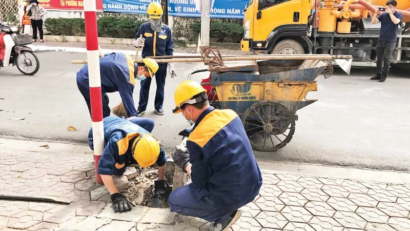 Công nhân Công ty Thoát nước Hà Nội nạo vét hệ thống thoát nước.