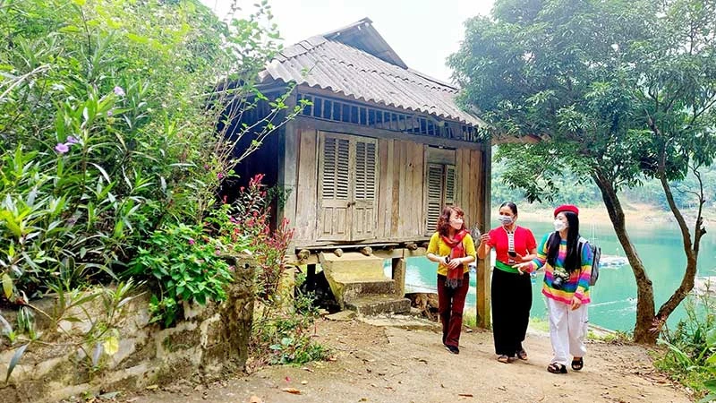 Người dân hướng dẫn du khách tham quan xóm Đá Bia (huyện Đà Bắc, tỉnh Hòa Bình). (Ảnh MAI MAI)