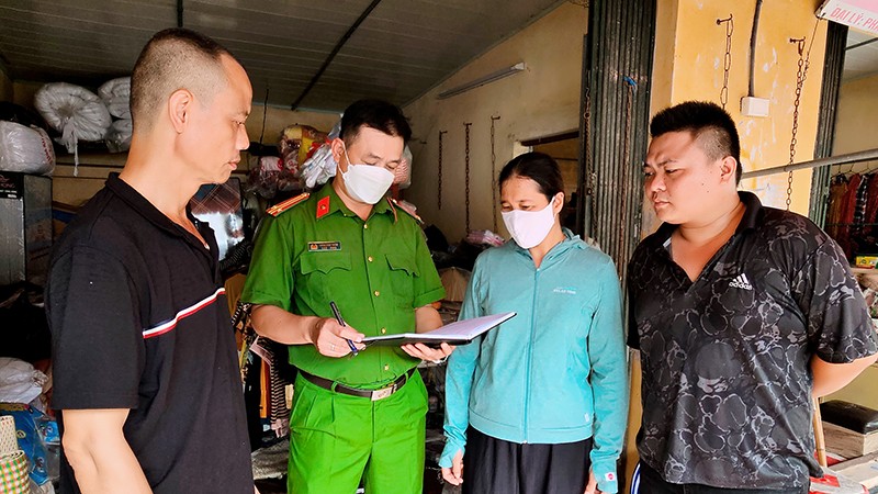 Cán bộ Công an xã Yên Mỹ, huyện Thanh Trì, TP Hà Nội hướng dẫn người dân phòng ngừa các thủ đoạn của tội phạm lạm dụng tín nhiệm chiếm đoạt tài sản. (Ảnh HUY HOÀNG)