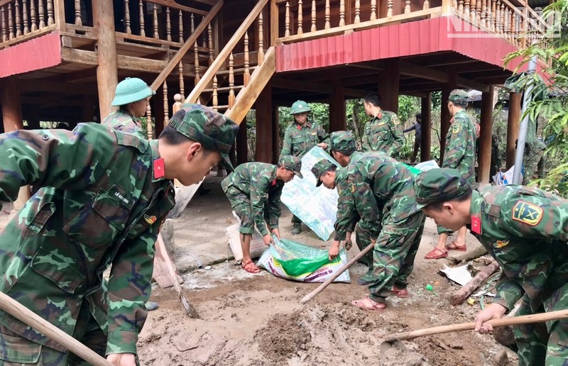 Cán bộ, chiến sĩ Tiểu đoàn 1, Trung đoàn 741 giúp người dân xã Mường Toong, huyện Mường Nhé sửa nhà.