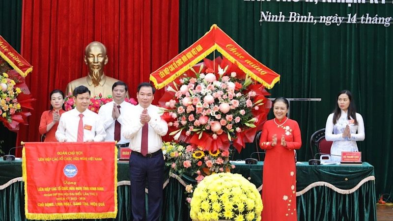 Đồng chí Nguyễn Phương Nga tặng hoa, cờ lưu niệm cho Đại hội. (Ảnh: Minh Quang)