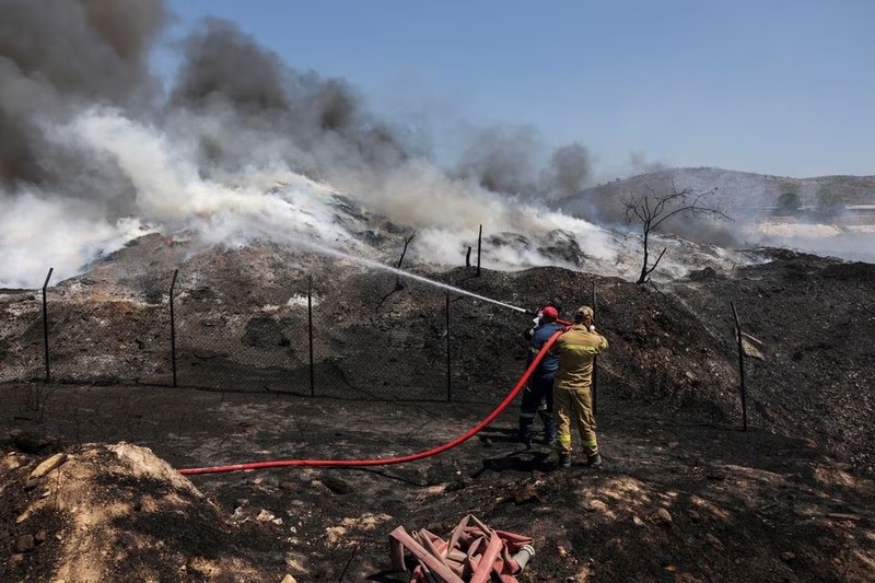 Lính cứu hỏa cố gắng dập tắt đám cháy tại một nhà máy tái chế, ở Sesklo, miền trung Hy Lạp, ngày 26/7. Ảnh: Reuters