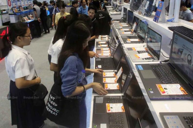 Các sinh viên đang tìm hiểu các loại máy tính xách tay trưng bày tại một hội chợ công nghệ. (Ảnh: Bưu điện Bangkok)