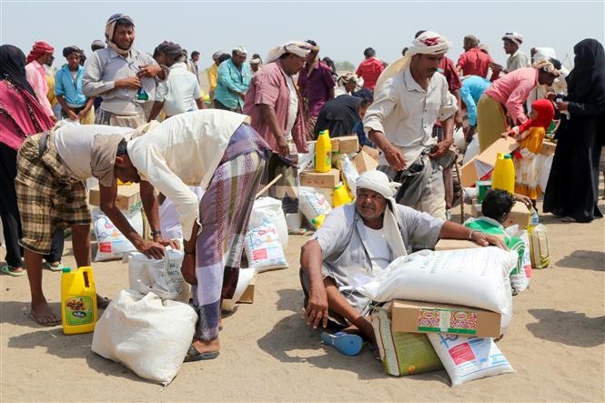 Người dân nhận hàng cứu trợ tại một trại tị nạn ở thành phố Hodeidah (Yemen) ngày 31/8/2022. (Ảnh: AFP/TTXVN)