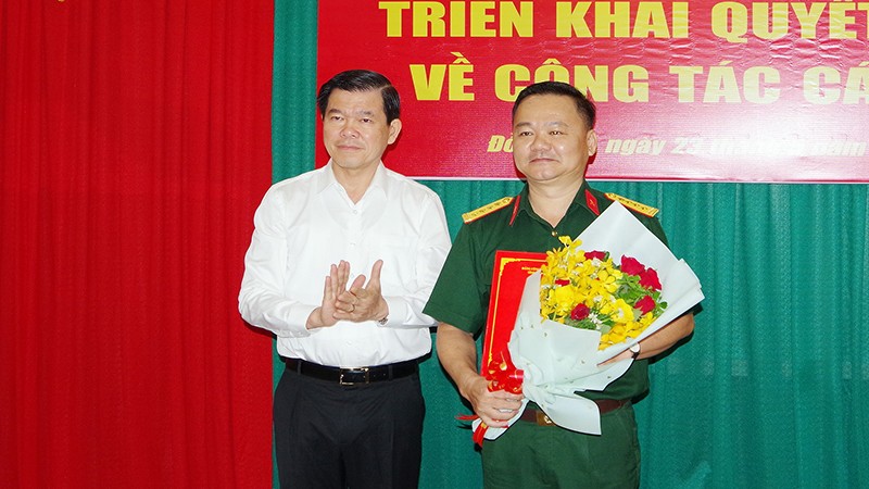 Đồng chí Nguyễn Hồng Lĩnh, Ủy viên Trung ương Đảng, Bí thư Tỉnh ủy, Bí thư Đảng ủy Quân sự tỉnh Đồng Nai trao quyết định và tặng hoa chúc mừng Đại tá Bùi Đăng Ninh.