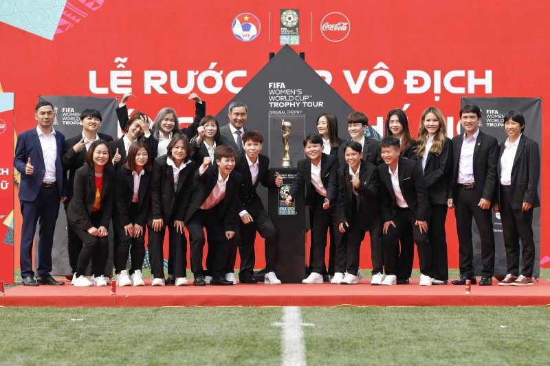 Các thành viên đội tuyển nữ Việt Nam bên cạnh Cúp vàng World Cup nữ. 
