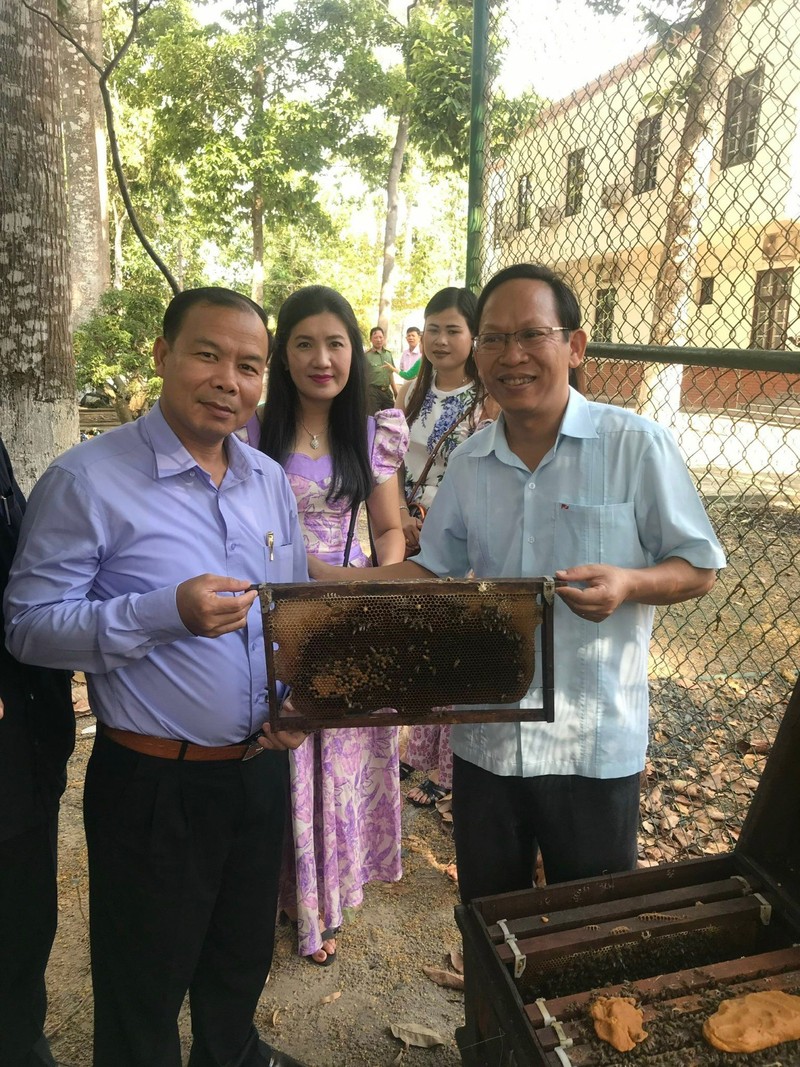 Anh Nguyễn Đình Xuân (bên phải) đang hướng dẫn kỹ thuật nuôi ong sinh thái cho cán bộ, nông dân Việt Nam và Campuchia.