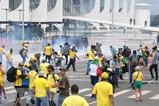 Lực lượng an ninh Brazil nỗ lực ngăn người biểu tình ủng hộ cựu Tổng thống Jair Bolsonaro tràn vào tòa nhà Quốc hội ở Brasilia, ngày 8/1/2023. (Ảnh: AFP/TTXVN)