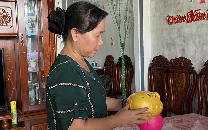 Hội viên Hội Phụ nữ huyện Trà Cú (Trà Vinh) nuôi heo đất tiết kiệm để tham gia bảo hiểm xã hội tự nguyện. (Ảnh KIM THANH) 