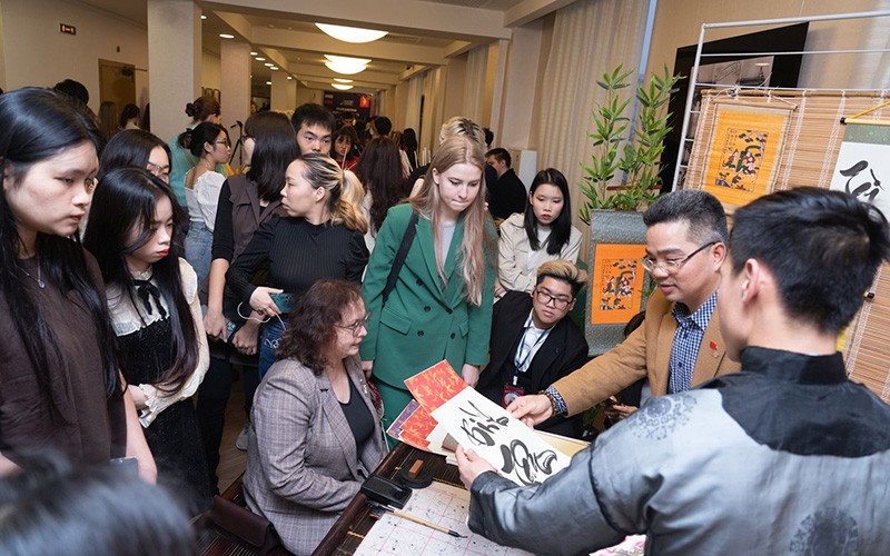 Sinh viên quốc tế tìm hiểu về thư pháp tại Ngày hội Việt Nam được tổ chức ở Nga. 