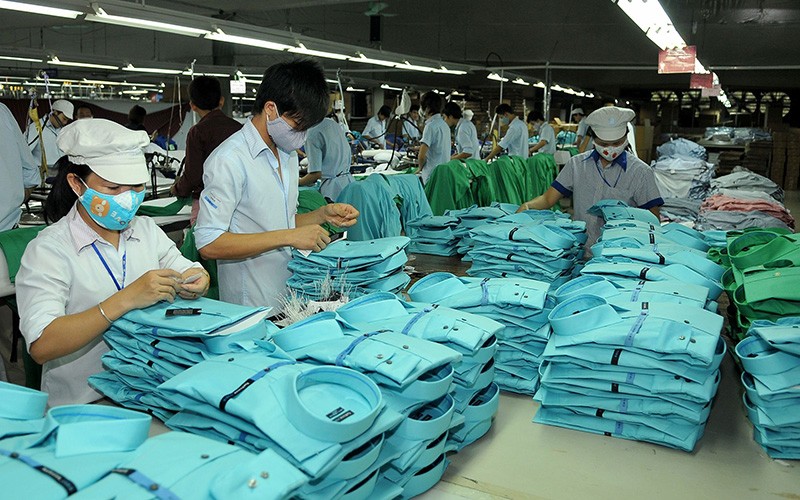 Công nhân may quần áo xuất khẩu tại Xí nghiệp may Hà Quảng, tỉnh Quảng Bình. (Ảnh NGUYỄN ÐĂNG) 
